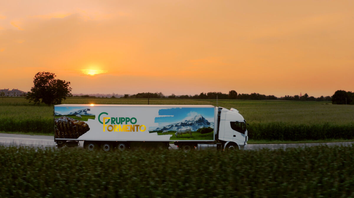 Camion Gruppo Formento per logistica carni e salumi. Trasporto refrigerato al tramonto.