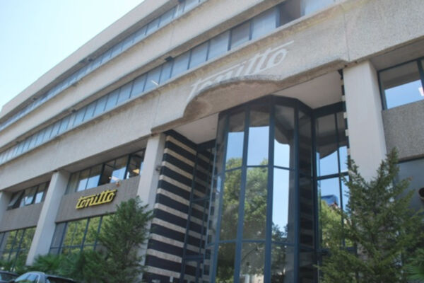 Esterno dell'azienda Tonitto 1939. Edificio con vetrate e logo. Gelati Tonitto, tradizione e qualità.