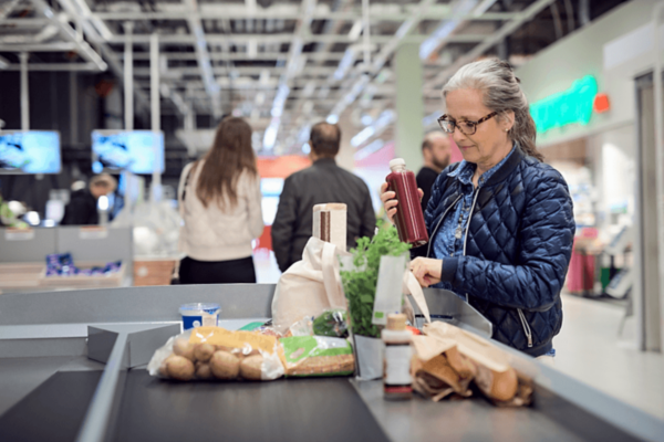 Donna al supermercato con prodotti alimentari. Webinar FSSC 24000 per responsabilità etico-sociale.