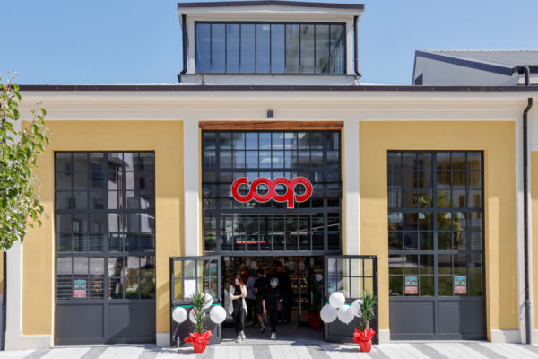 Facciata del negozio Coop, insegna rossa Coop, architettura moderna, ingresso aperto.