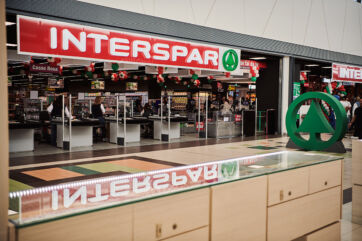 Nuovo Interspar Maiora: ingresso al supermercato con casse e insegna rossa. Spesa completa e responsabile.