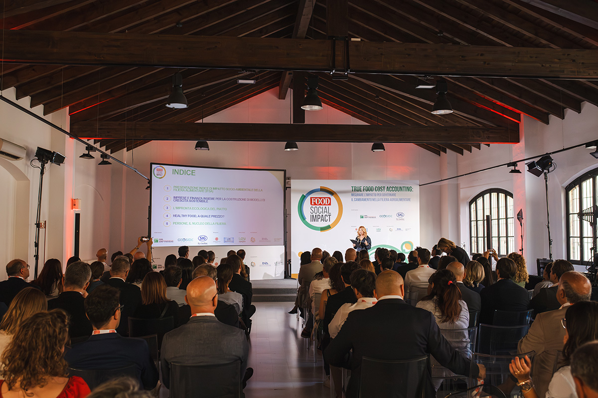Evento Food Social Impact: pubblico assiste a presentazione sulla sostenibilità alimentare.