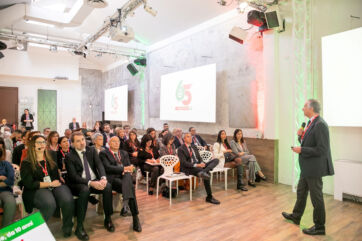 Evento Despar Italia: relatore e pubblico celebrano i 65 anni del marchio. Insegna Despar proiettata sullo schermo.