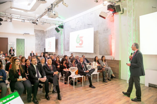 Evento Despar Italia: relatore e pubblico celebrano i 65 anni del marchio. Insegna Despar proiettata sullo schermo.