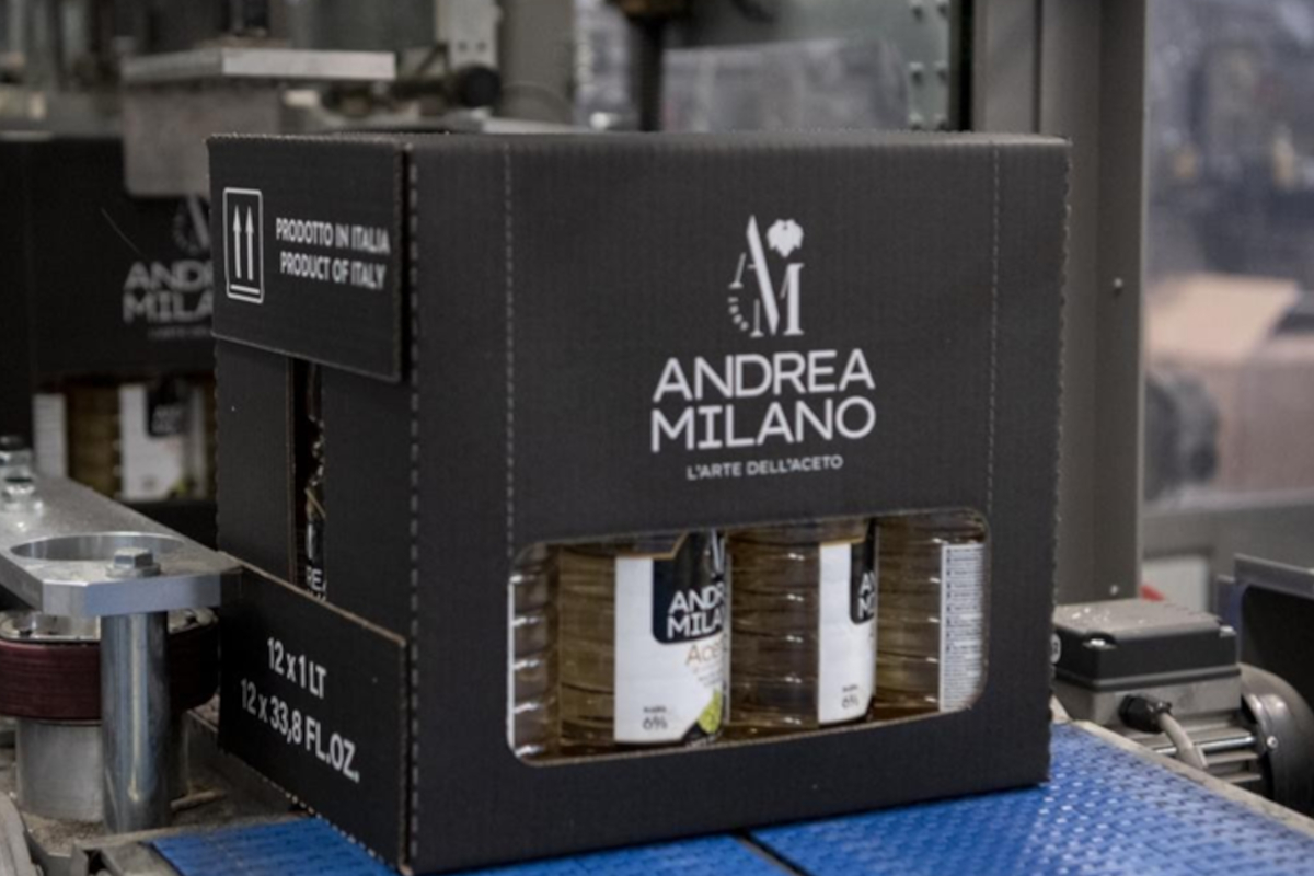 Scatola di Aceto Andrea Milano su nastro trasportatore. Bottiglie di aceto Made in Italy.