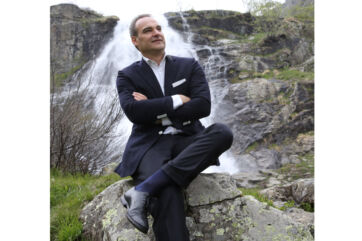 Alberto Bertone, fondatore Acqua Sant'Anna, seduto davanti cascata. Imprenditore italiano, acqua minerale.