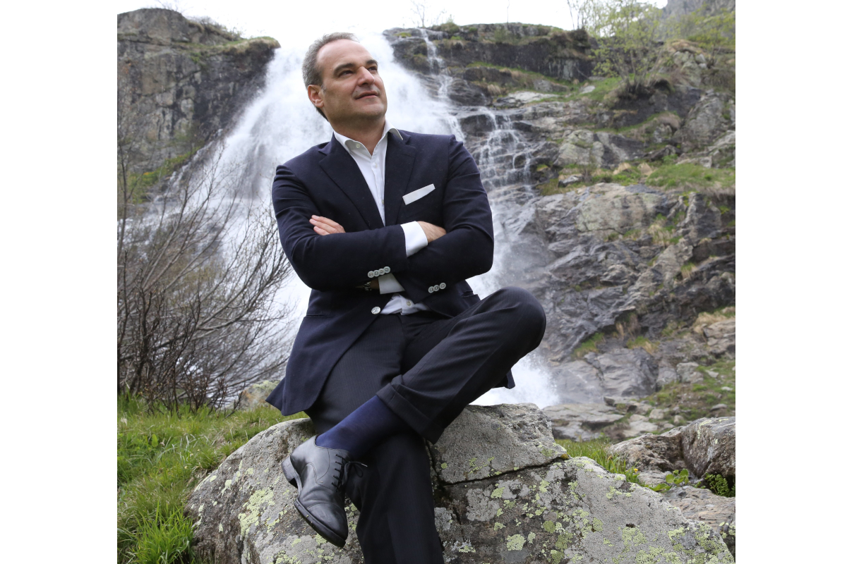 Alberto Bertone, fondatore Acqua Sant'Anna, seduto davanti cascata. Imprenditore italiano, acqua minerale.