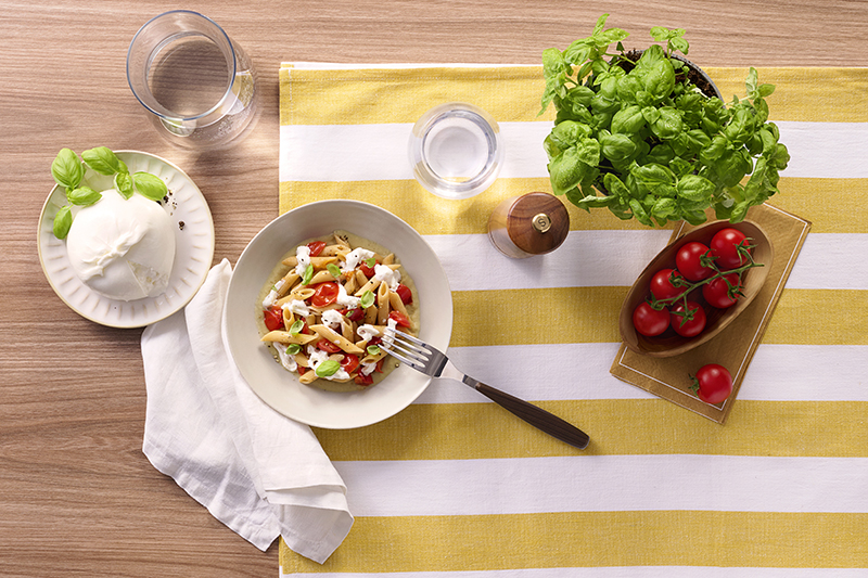 Piatto di penne Barilla Protein+, pomodorini, mozzarella e basilico fresco. Ricetta gustosa e proteica.