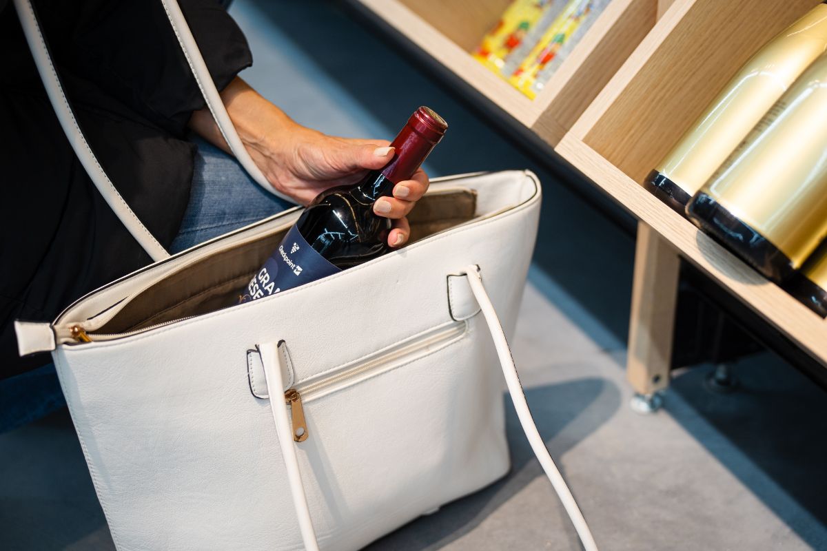 Furto retail: bottiglia di vino nascosta in borsa. Aumento perdite nel retail.