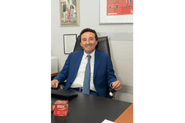 Giancarlo Paola, Gruppo Unicomm, seduto alla scrivania. Intesa GMF-Etruria Retail, distribuzione alimentare centro Italia.