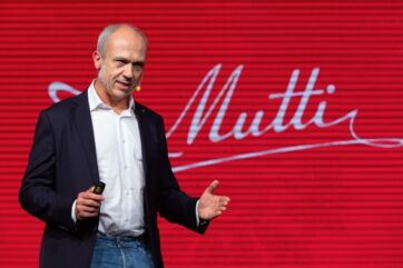 Premio Mutti qualità: uomo sul palco con logo Mutti sullo sfondo rosso. Agricoltori italiani premiati.