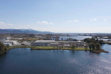 Stabilimento Salov, azienda olio vista dal lago. Paesaggio industriale e naturale.