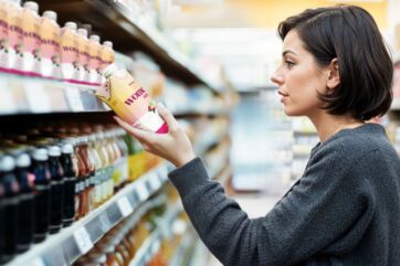 Donna guarda bevanda Wome Daily. Trend nutrizione Tetra Pak: bevande salutari, alimentazione sana, benessere.