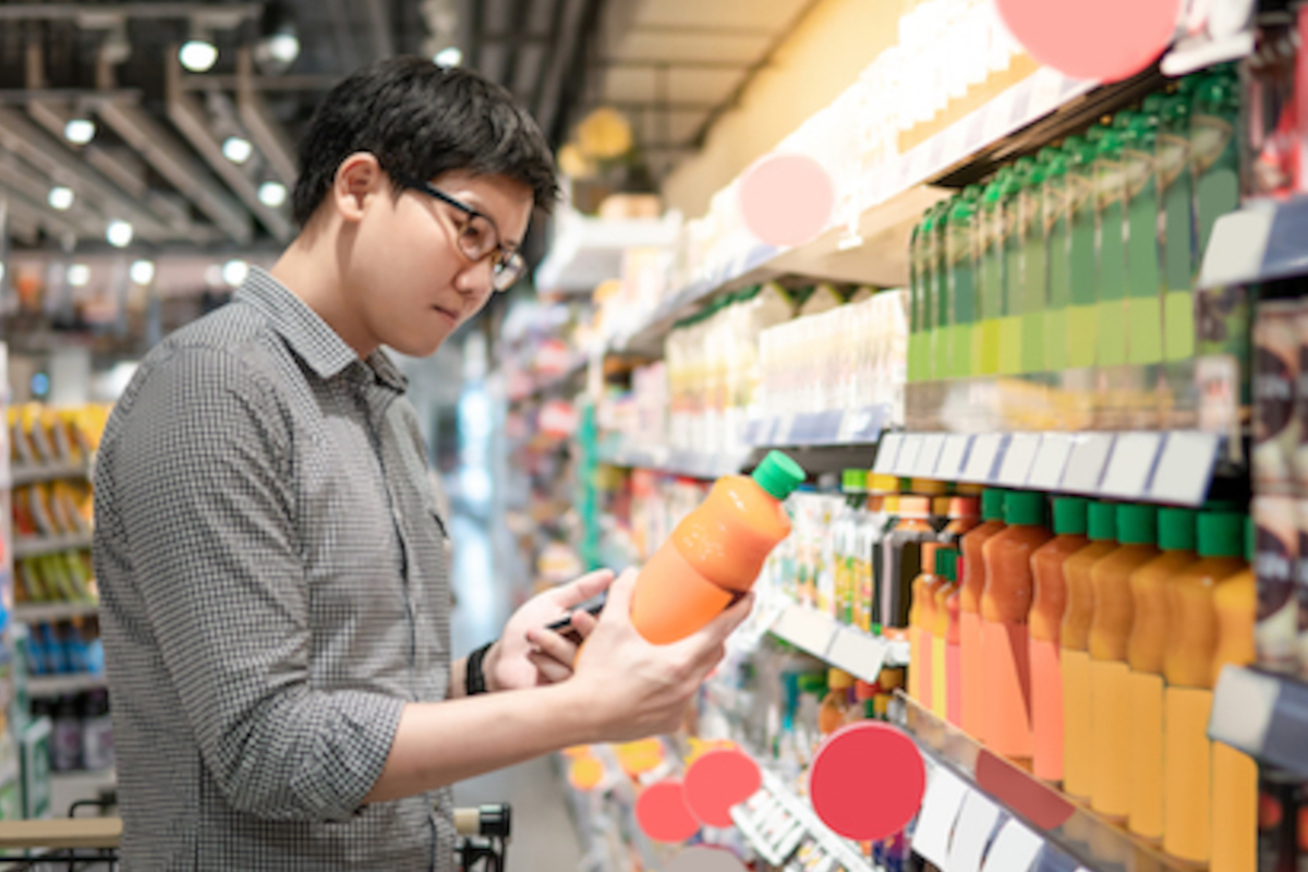 Uomo al supermercato sceglie succo d'arancia. Acquisti alimentari, scaffale bevande, spesa. - Mdd