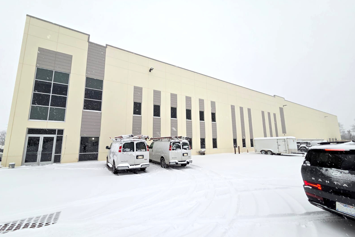 Stabilimento Il Pastaio USA sotto la neve. Furgoni parcheggiati, architettura moderna.