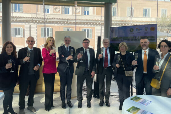 Presentazione report NielsenIQ sui formaggi italiani. Gruppo di persone brinda con champagne. Settore lattiero caseario.