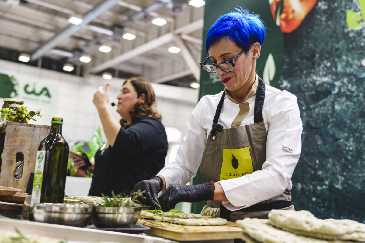 Chef al SANA Food 2025 prepara focaccia. Cucina naturale, prodotti biologici, fiera alimentare a Bologna.