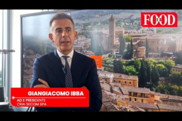 Giangiacomo Ibba, AD Crai Secom Spa, in primo piano. Borgo toscano e logo Food sullo sfondo.