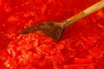 Salsa di pomodoro fatta in casa. Cucchiaio di legno nella passata di pomodoro. Ricetta tradizionale italiana.