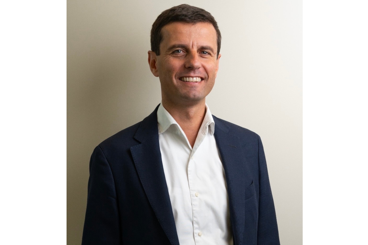 Ritratto di Enrico Amesso, uomo in giacca blu e camicia bianca. Sorriso, sguardo diretto. - Fabbri 1905