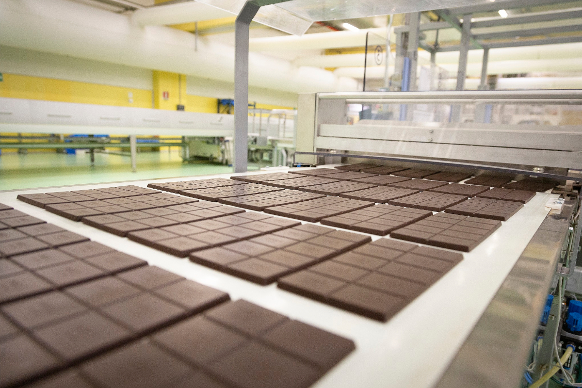 Cioccolato Icam Agostoni in produzione. Tavolette di cioccolato su nastro trasportatore. Fabbrica di cioccolato a Orsenigo.