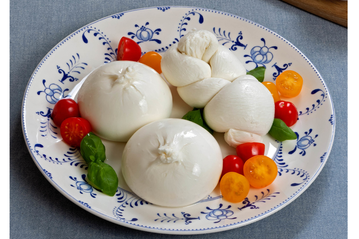Burrata di Andria e mozzarella di Gioia del Colle DOP con pomodorini. Formaggio fresco italiano.