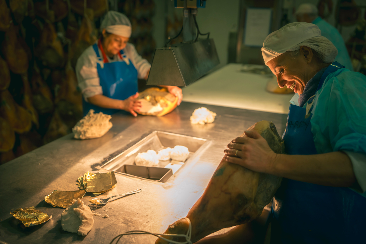 Lavorazione artigianale del Prosciutto di Parma. Donne al lavoro, sugnatura del prosciutto. Tradizione e qualità. - gruppo Pini