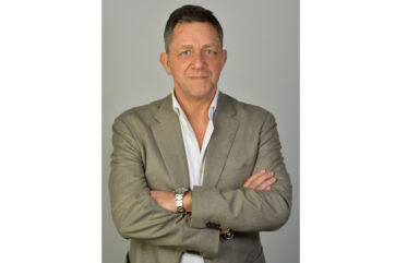 Ritratto di Vladimir Dukcevich, AD di Cesare Fiorucci SPA, in giacca e camicia bianca, braccia conserte.