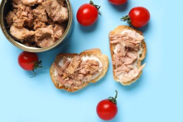 Tonno in scatola con pomodorini e pane. Snack con tonno sott'olio.