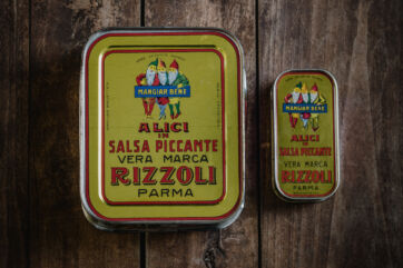Lattine vintage Rizzoli Emanuelli di alici in salsa piccante. Packaging storico, tradizione e qualità dal 1906.
