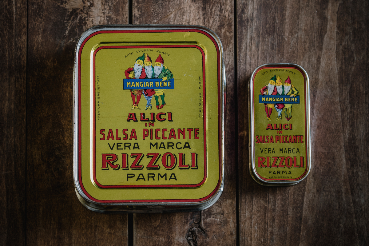 Lattine vintage Rizzoli Emanuelli di alici in salsa piccante. Packaging storico, tradizione e qualità dal 1906.