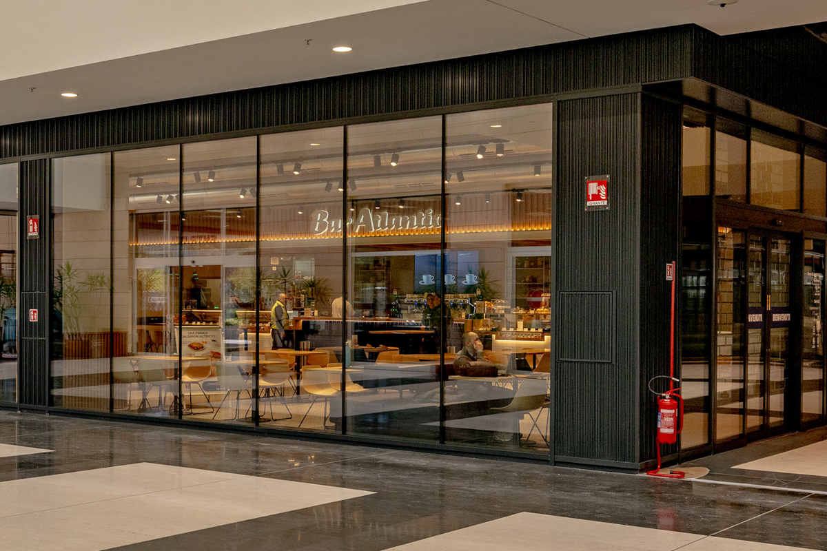 Bar Atlantic Milano: vetrina del locale con tavoli e sedie. Nuova apertura, design moderno.