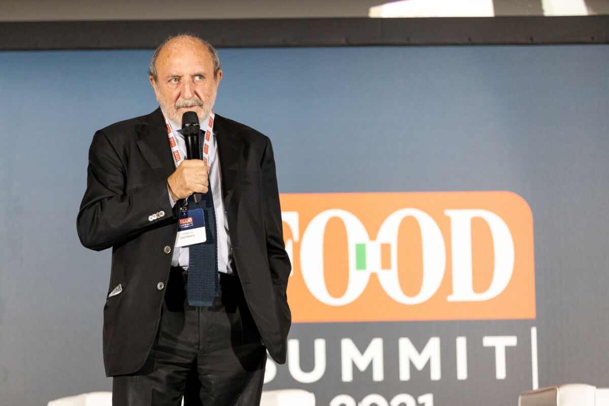 Relatore al FOOD Summit 2021. Evento food, community e valore. Uomo con microfono durante conferenza.