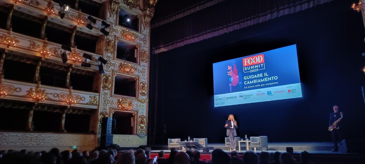 Food Summit 2023: evento community. Oratrice sul palco, maxi schermo, platea gremita, teatro storico.