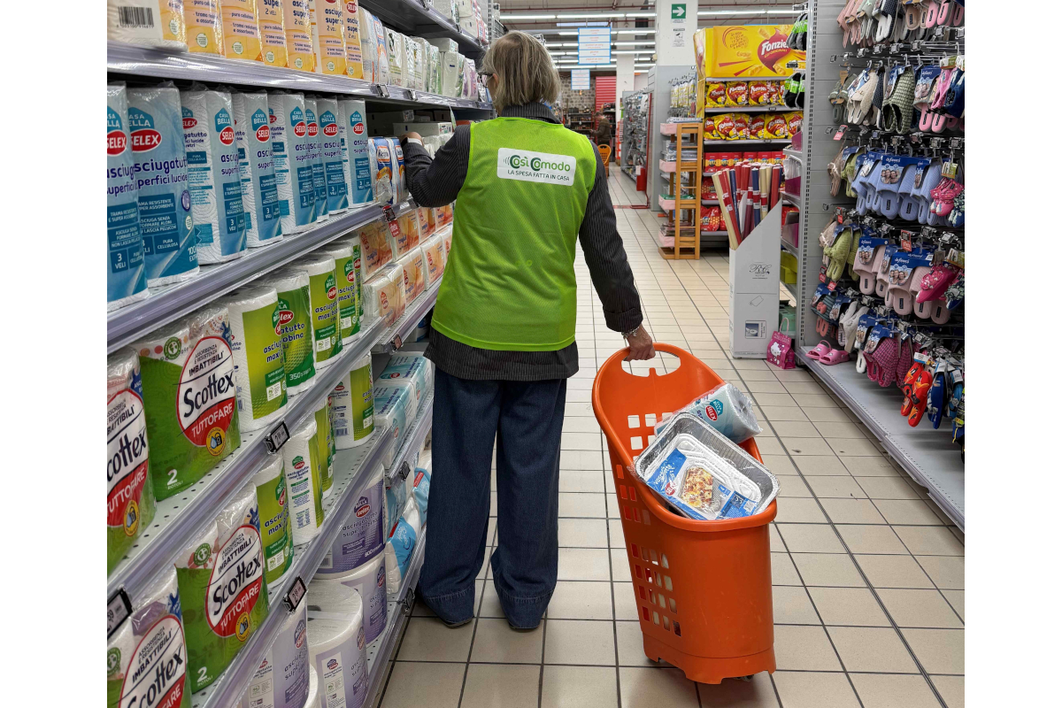 CosìComodo a Campobasso: addetta fa la spesa al supermercato. Carrello arancione pieno.