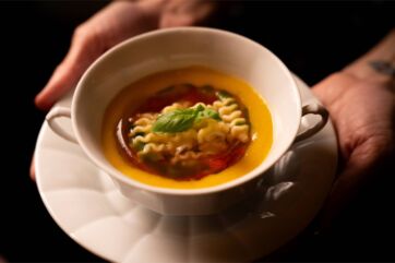 Zuppa di pasta Barilla Riccioli in tazza. Minestra gourmet con basilico fresco. Ricetta italiana.