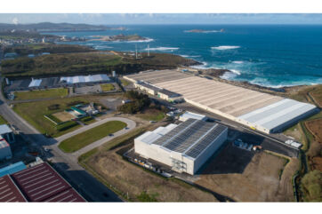 Vista aerea di Cervo Stolt Sea Farm Neptuna. Edifici industriali, costa, mare e pannelli solari.