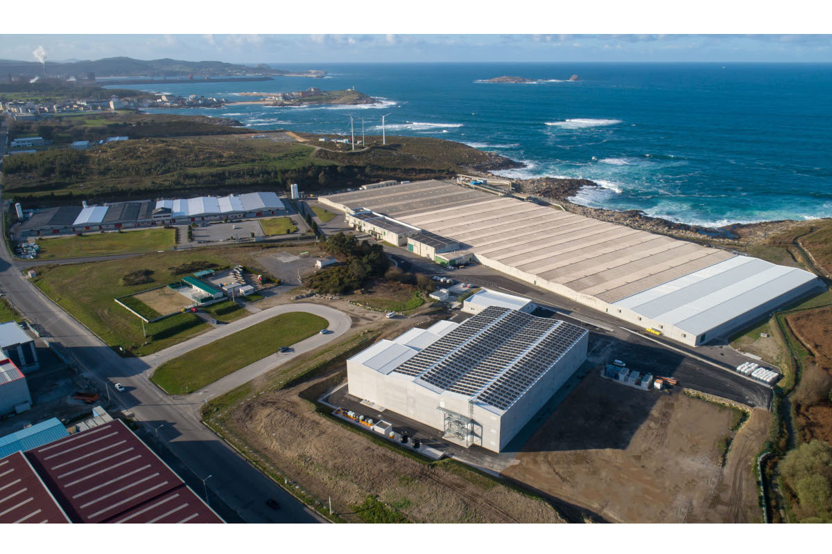 Vista aerea di Cervo Stolt Sea Farm Neptuna. Edifici industriali, costa, mare e pannelli solari.