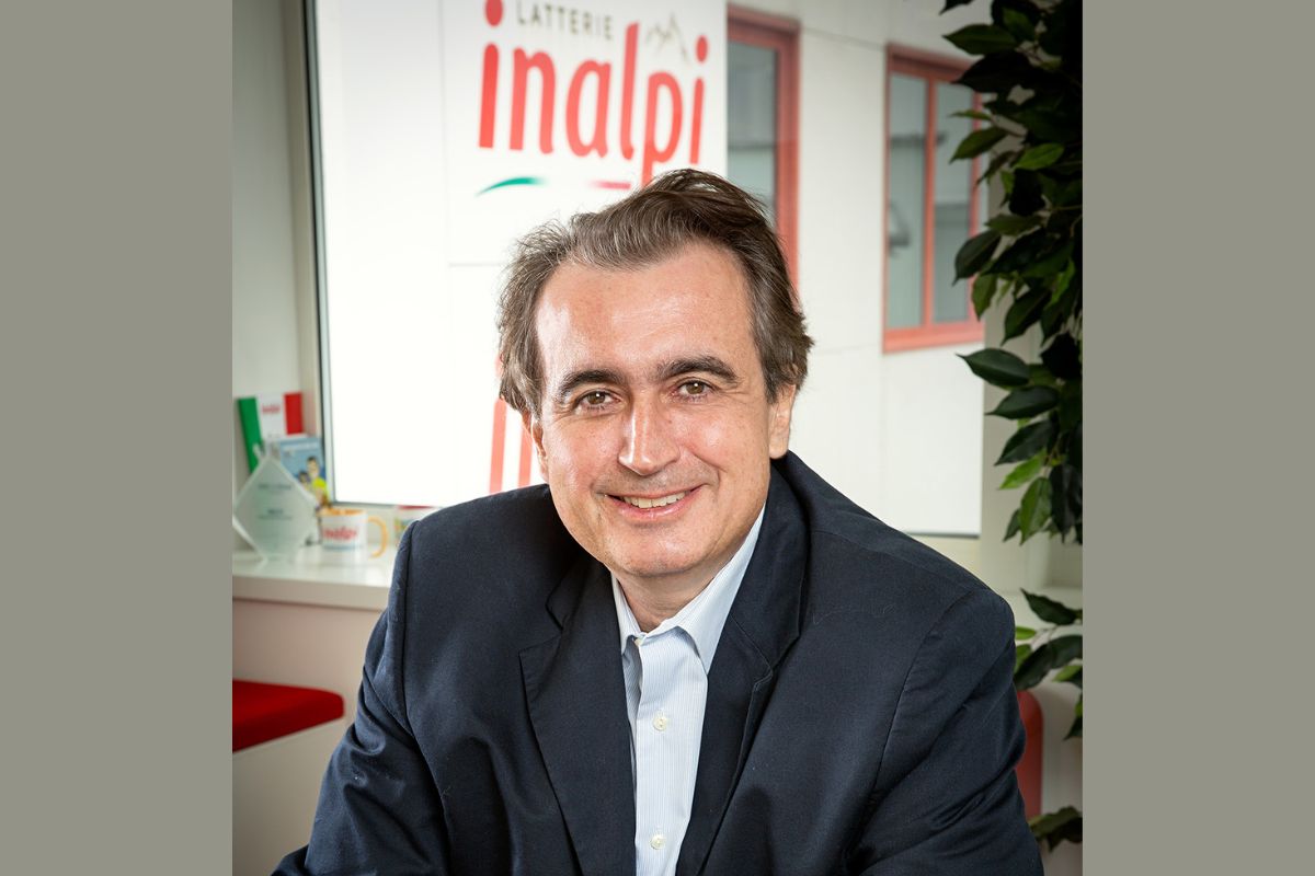 Ritratto del presidente Inalpi, azienda lattiero-casearia hi-tech, con logo Inalpi sullo sfondo.
