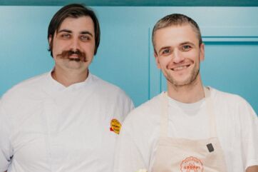 Pastificio Groppi: due chef sorridenti in divisa bianca e grembiule. Cucina artigianale, pasta fresca.