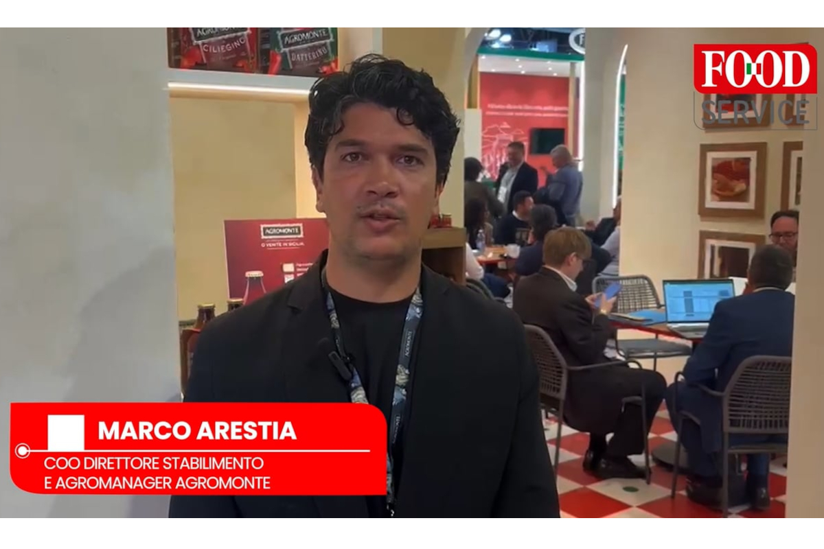 Agromonte a Tuttofood 2026: Marco Arestia presenta la nuova linea Pizza Sauce. Stand affollato, atmosfera vivace.