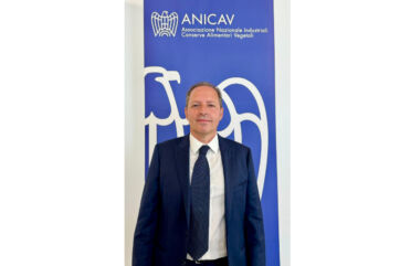 Aldo Rodolfi, nuovo Presidente Anicav. Ritratto formale su sfondo blu con logo Anicav - conserve alimentari vegetali.