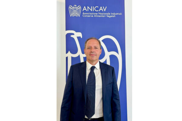 Aldo Rodolfi, nuovo Presidente Anicav. Ritratto formale su sfondo blu con logo Anicav - conserve alimentari vegetali.