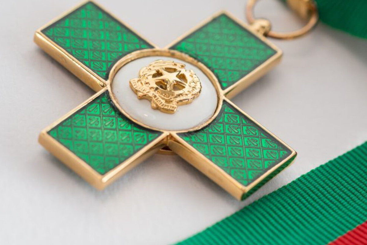 Onorificenza Cavalieri del Lavoro. Croce smaltata verde e oro, simbolo del Made in Italy e dell'eccellenza italiana.