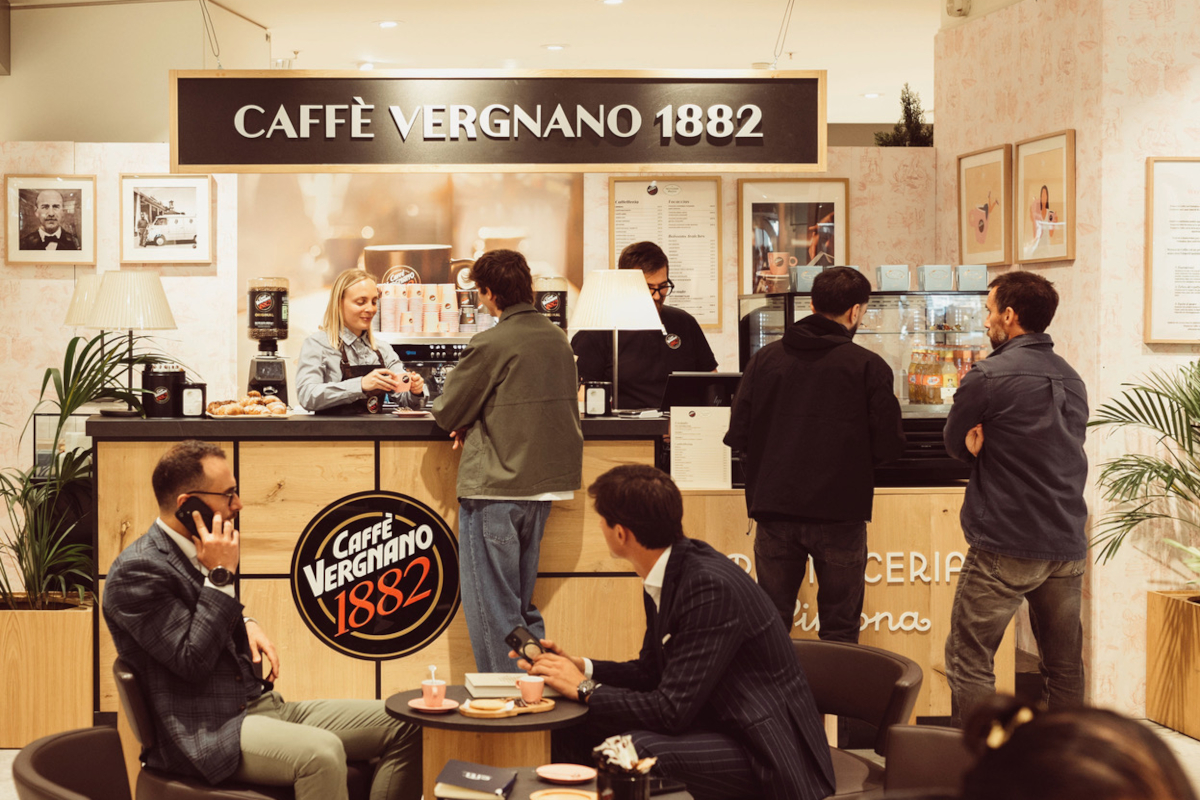 Caffè Vergnano 1882: caffetteria affollata. Persone gustano caffè e bevande. Design moderno e accogliente.
