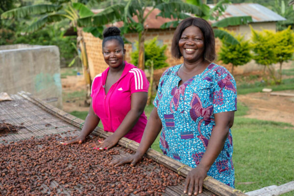 Donne Fairtrade sorridono vicino al cacao. Agricoltura sostenibile, commercio equo e solidale.