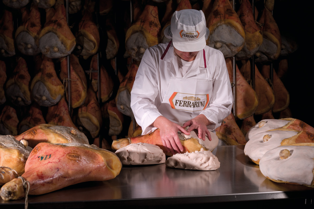 Lavorazione artigianale del prosciutto crudo Ferrarini. Salumi tipici italiani.
