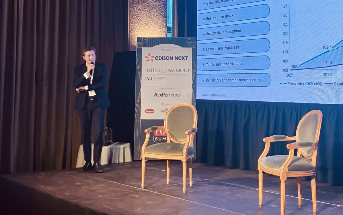 Relatore al Food Summit 2026. Volatilità, valore durevole nel settore alimentare. Grafici e sedie sul palco.
