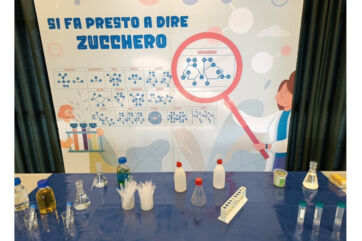 Laboratorio didattico Zucchero & Co Eridania. Vetrina con provette, beute e poster scientifico sullo zucchero - Eridania