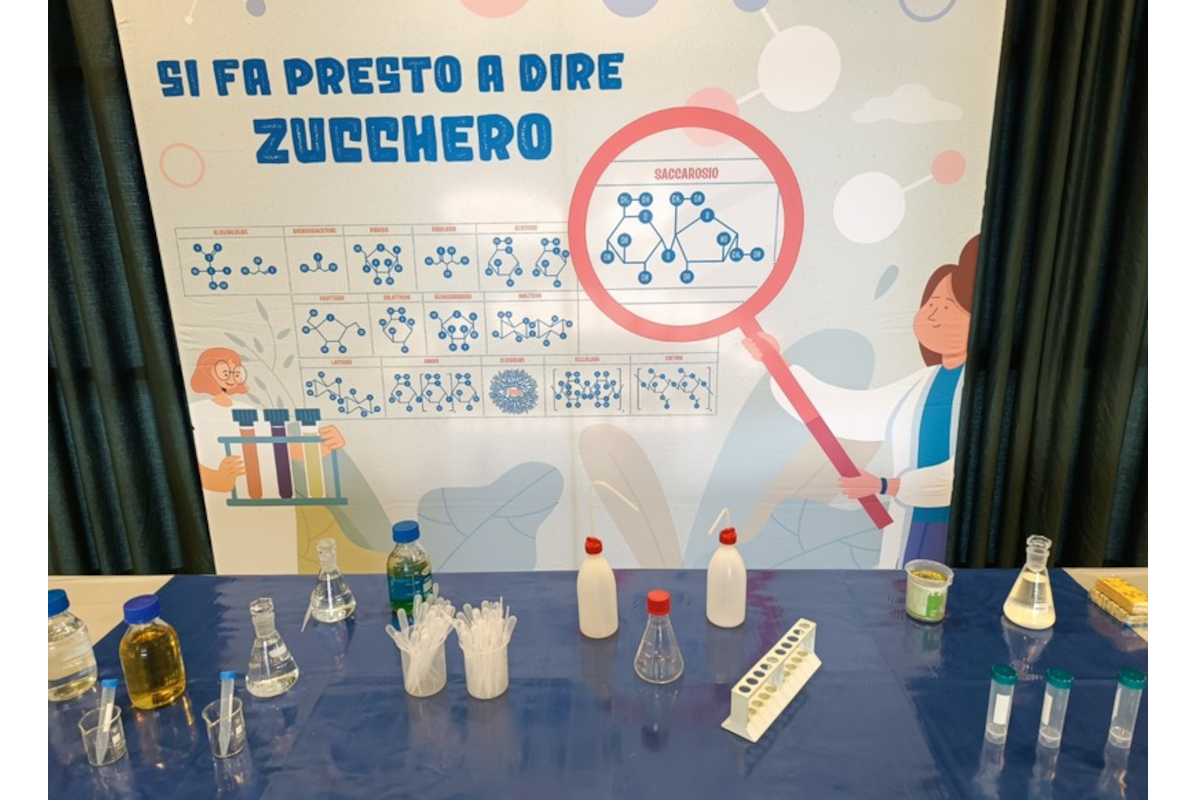 Laboratorio didattico Zucchero & Co Eridania. Vetrina con provette, beute e poster scientifico sullo zucchero - Eridania